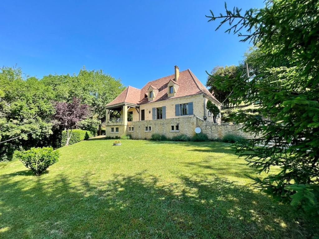 uma antiga casa de pedra com um grande quintal em Villa Joséphine - Maison de Charme à Beynac em Beynac-et-Cazenac