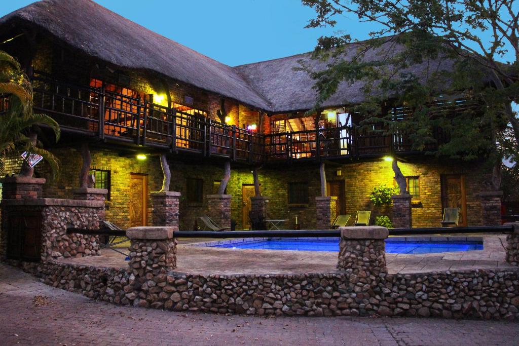 a house with a swimming pool in front of it at Jabula Lodge in Marloth Park