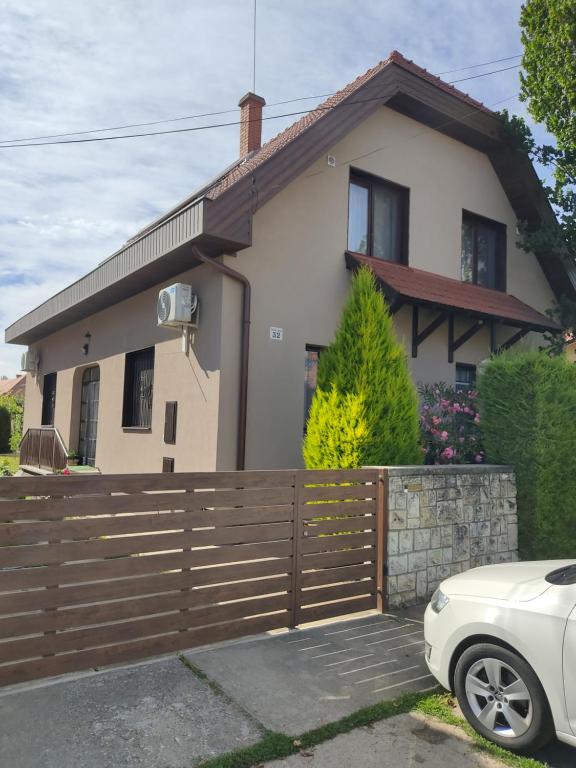 a white car parked in front of a house at Arnika Vendégház in Hajdúszoboszló