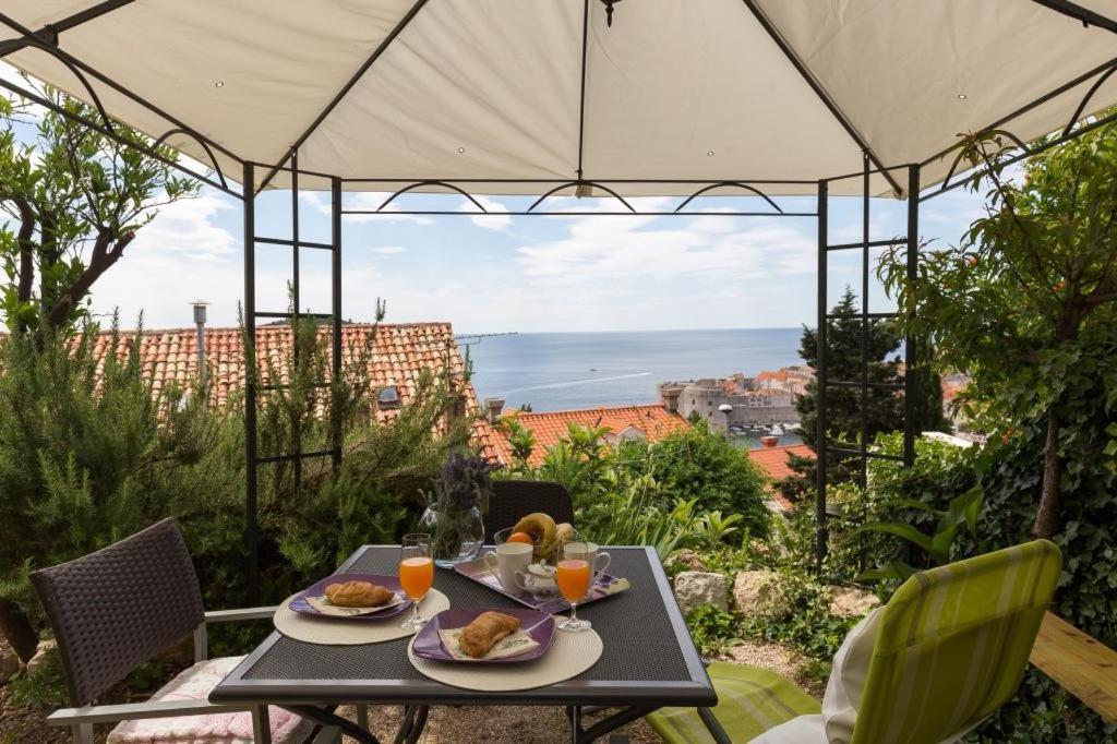- une table avec de la nourriture et des boissons sur un balcon avec vue dans l'établissement Apartment Purple Rain, à Dubrovnik
