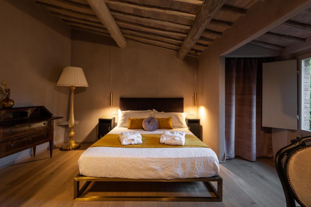 a bedroom with a bed with two towels on it at Drogheria e Locanda Franci in Montalcino