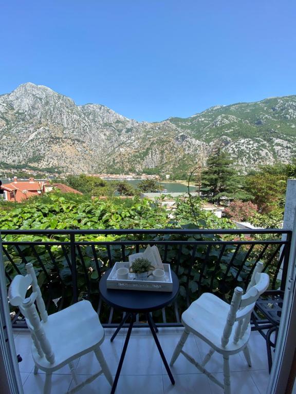 balcón con mesa, sillas y montañas en M&B apartment en Kotor