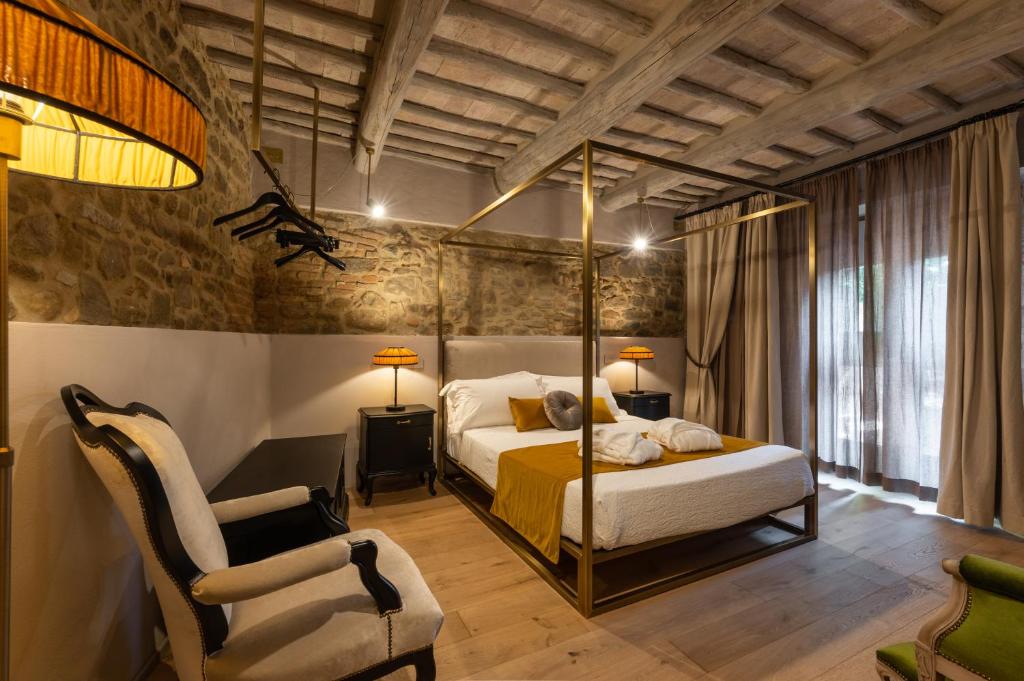 a bedroom with a bed and a chair at Drogheria e Locanda Franci in Montalcino