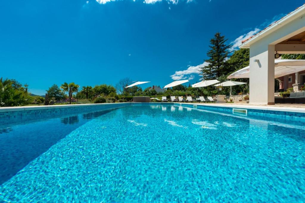 una gran piscina de agua azul en Villa Thousand Roses, en Lovorno