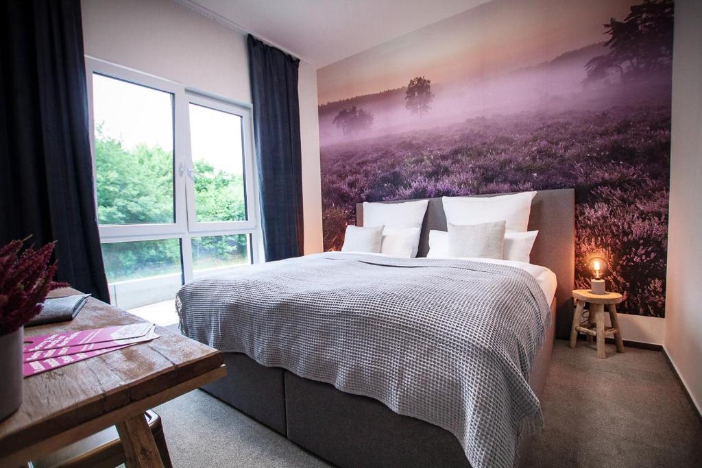 sypialnia z dużym łóżkiem i dużym oknem w obiekcie Resort Hotel Bispingen Superior w mieście Bispingen