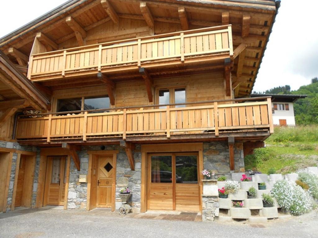 ムジェーヴにあるAppartement les 4 Montsの木造の家屋で、バルコニーが付いています。