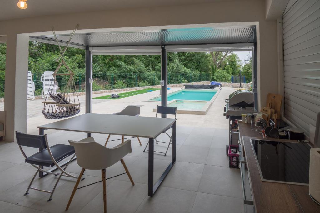 a kitchen with a table and chairs and a swimming pool at Villa Kamena in Vitina