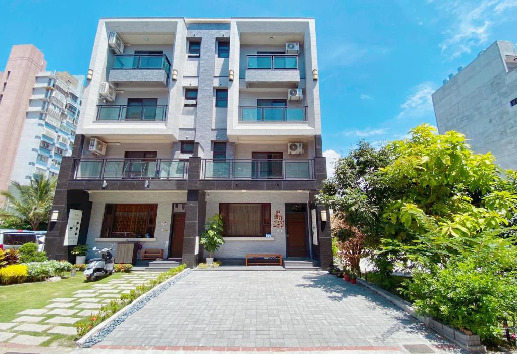 a tall white building with a courtyard in front of it at 花蓮 Cozy Stay 舒適好宅 in Hualien City