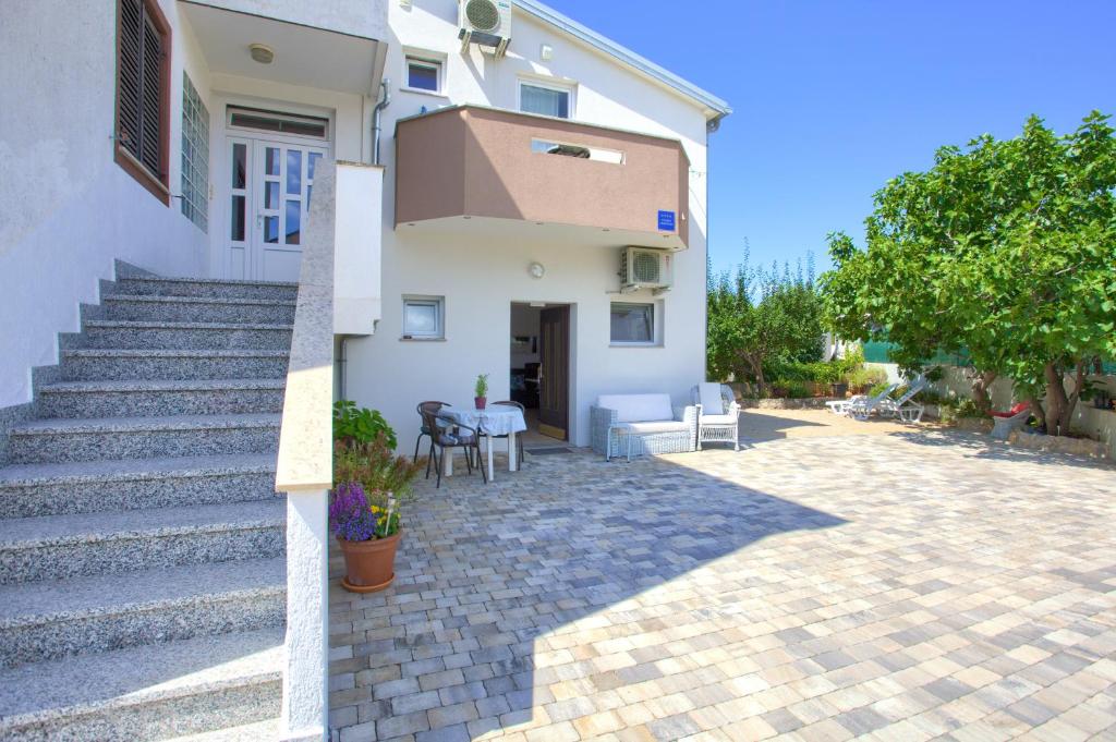 una casa bianca con scale e patio di Apartment Nena a Krk