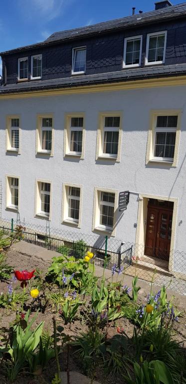 a white house with a garden in front of it at Ferienwohnungen Altstadtherz in Annaberg-Buchholz