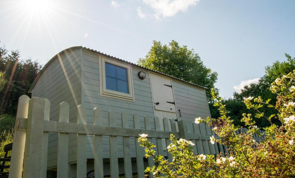 una casita detrás de una valla en Hilltop Hut, en Church Stretton