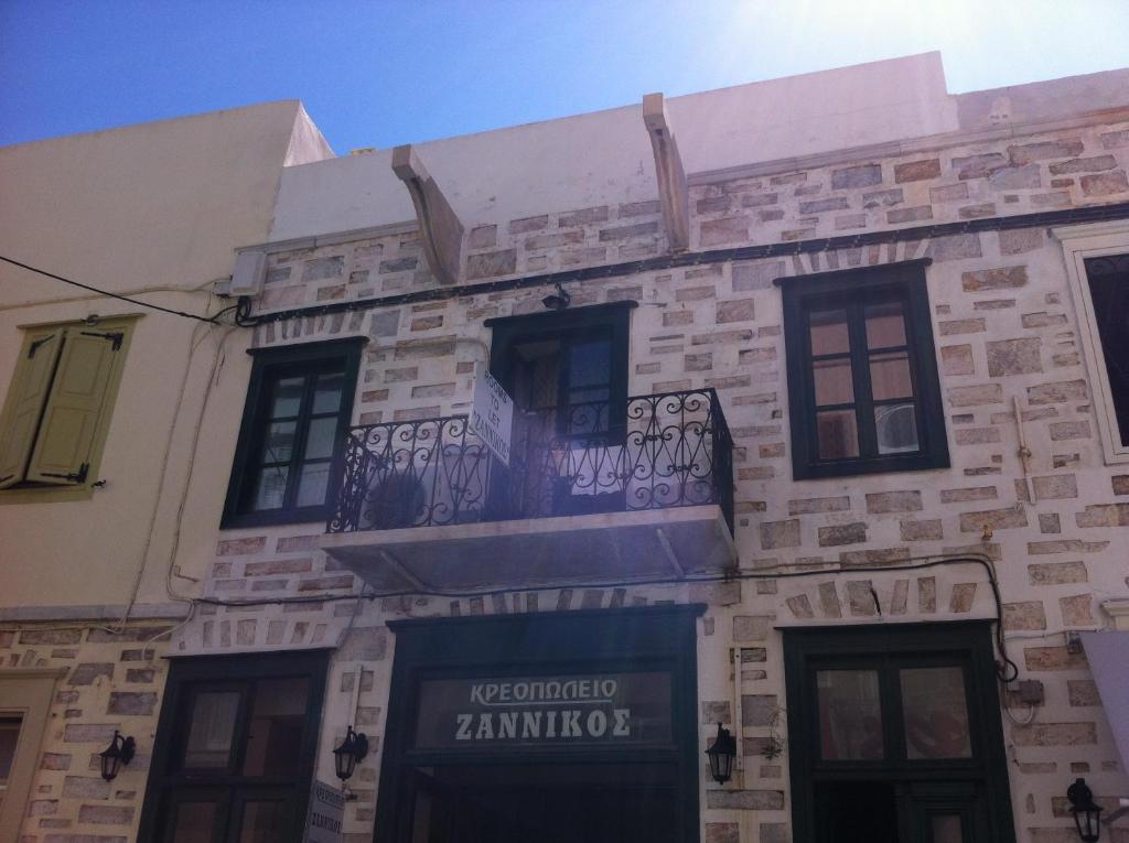 un edificio con un balcón en el lateral. en Zannikos Rooms, en Ermoupoli