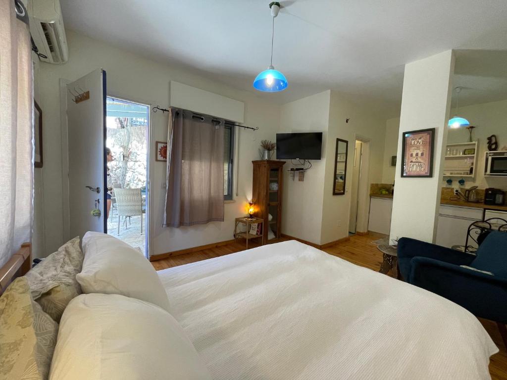 a bedroom with a white bed and a couch at Netta's Place in Mitzpe Hila