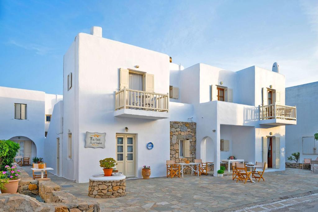 a white building with tables and chairs in front of it at Twins Apartments By Mina in Ornos