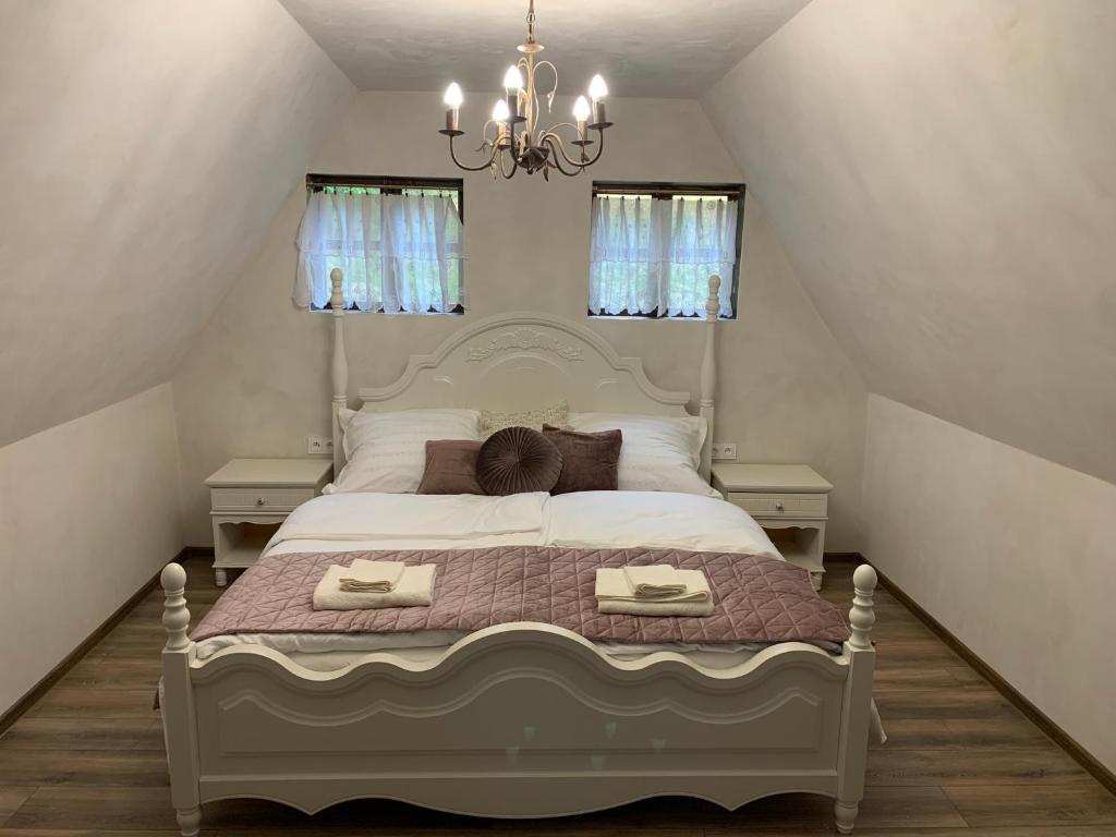 a bedroom with a large bed with a chandelier at Apartmán Vila Rosenberg in Banská Štiavnica