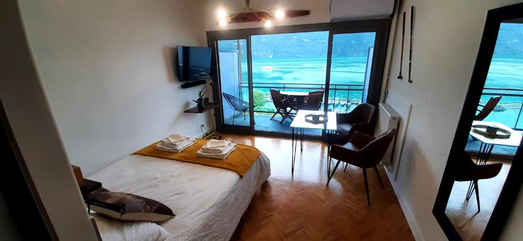 een kamer met een bed en een balkon met een tafel bij Studio Le 119, Aix les bains - Grand port - Vue Lac splendide in Aix-les-Bains