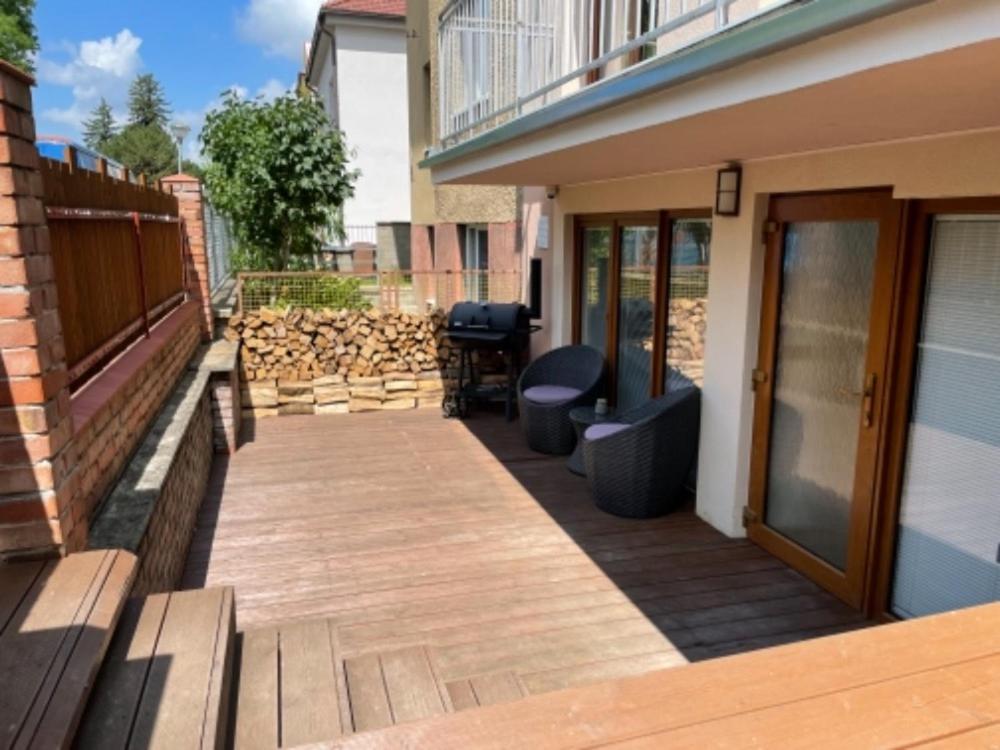 a patio with a wooden walkway next to a building at Apartmán u Jiříka in Poděbrady