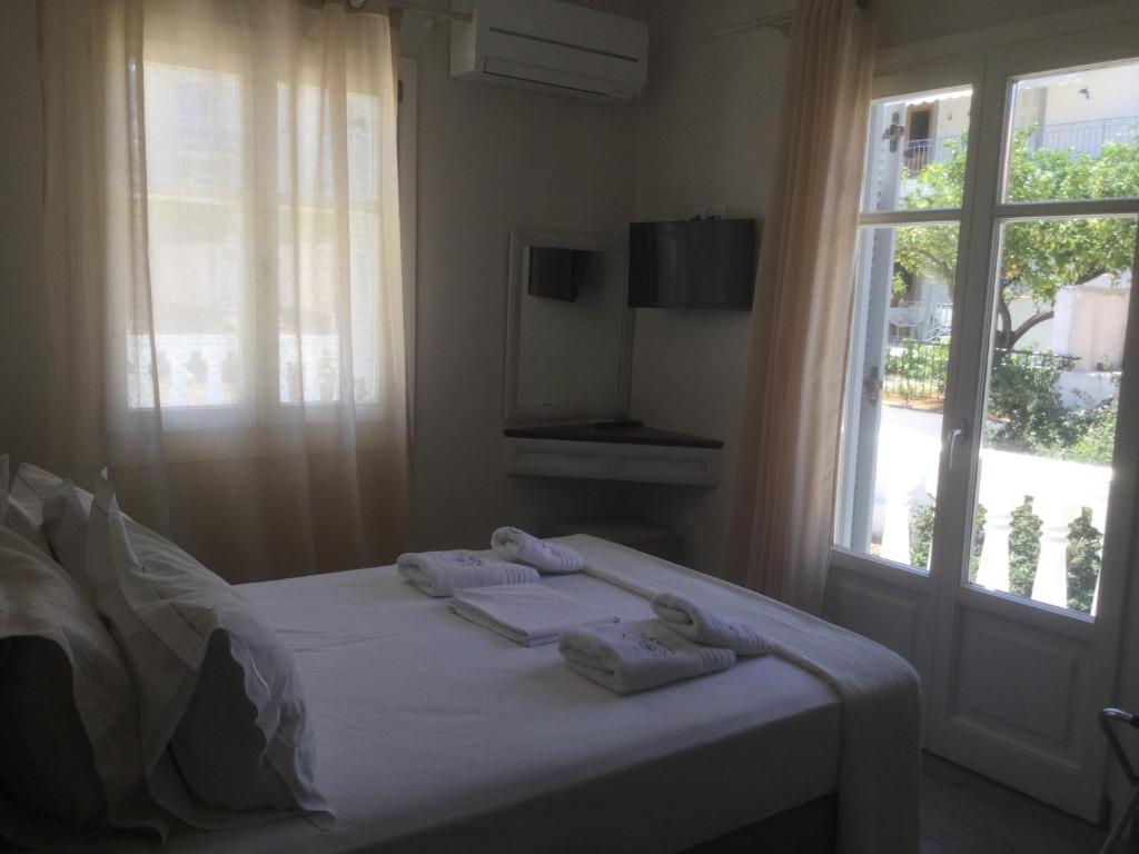 1 dormitorio con 1 cama con toallas en Kochyli Hotel en Spetses