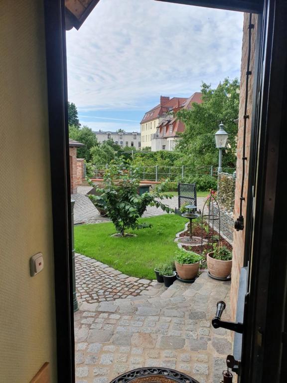 an open door with a view of a garden at Ferienhaus am Wasserturm Angermünde in Angermünde
