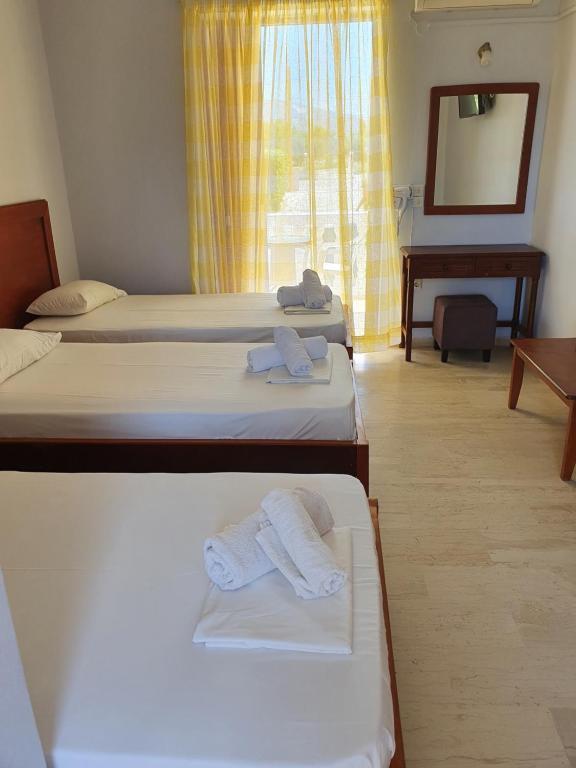 a room with three beds with towels on them at Rivulet Studios in Laganas