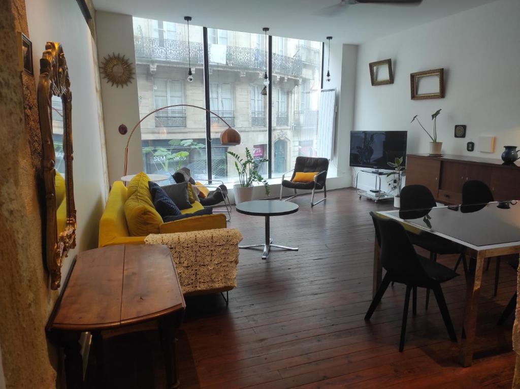 a living room with a yellow couch and a table at Studio Bordeaux in Bordeaux