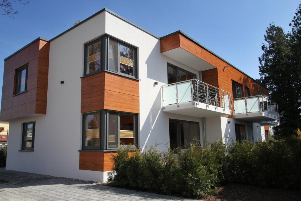 Casa blanca con ventanas y balcones negros en Die Bleibe, en Ahlbeck
