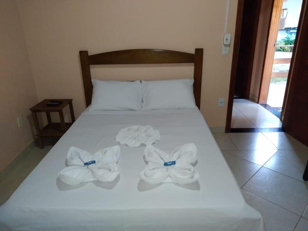 a bed with white sheets and towels on it at Pousada Licuri in Serra do Cipo