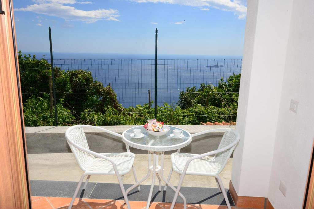 een tafel en stoelen op een balkon met uitzicht bij Casa Satriano 2 in Positano