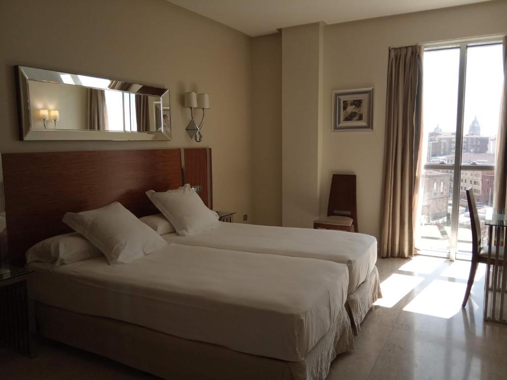 Postel nebo postele na pokoji v ubytování Gran Hotel Corona Sol