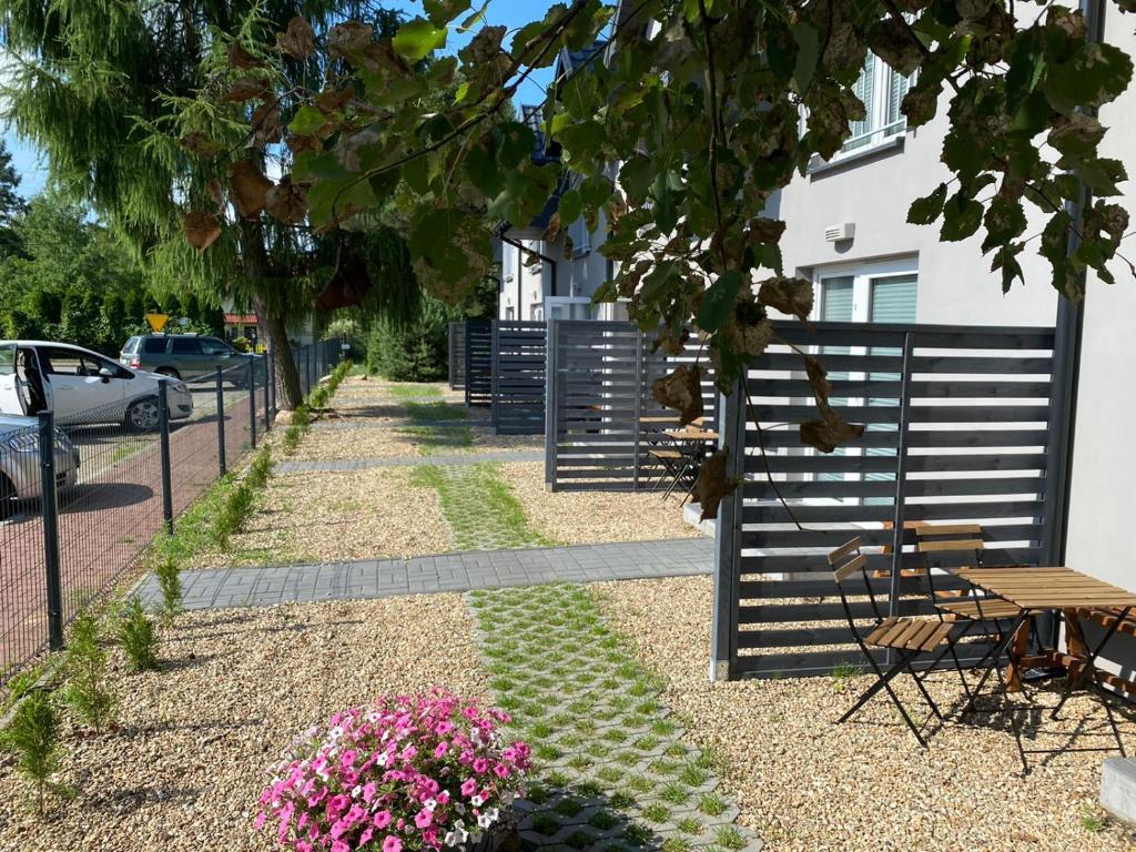un giardino con recinto e alcuni fiori rosa di Apartamenty Pasternik 7 SUCHEDNIÓW a Suchedniów