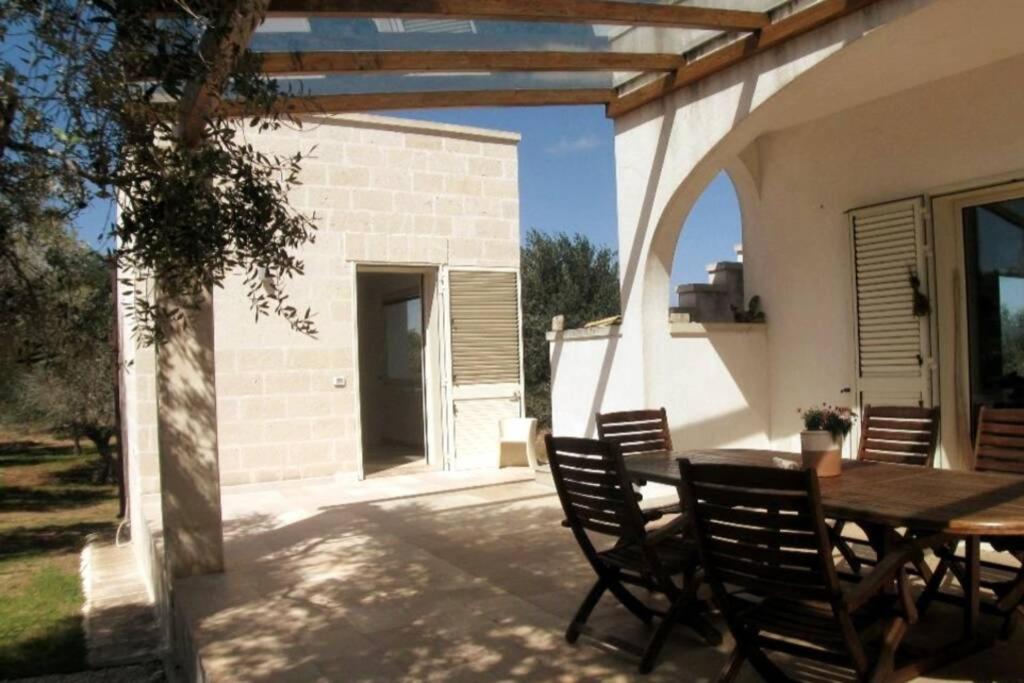 un patio con mesa y sillas y un edificio en Otranto d'Amare, en Casamassella