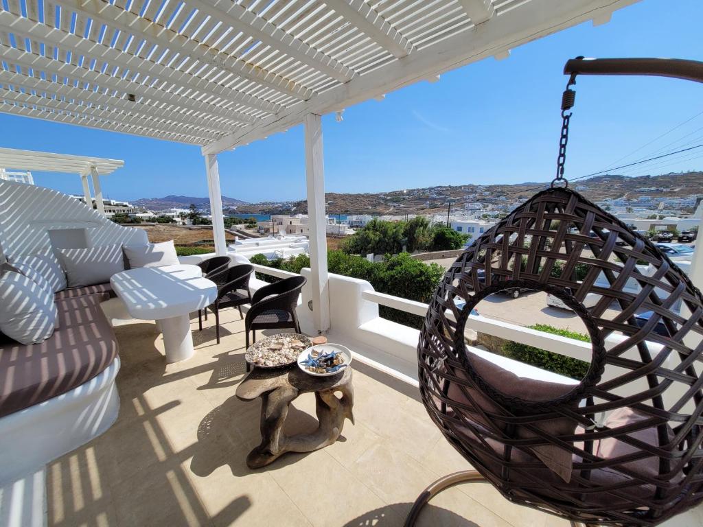 a porch with a swing and a table at Villa Elena in Ornos
