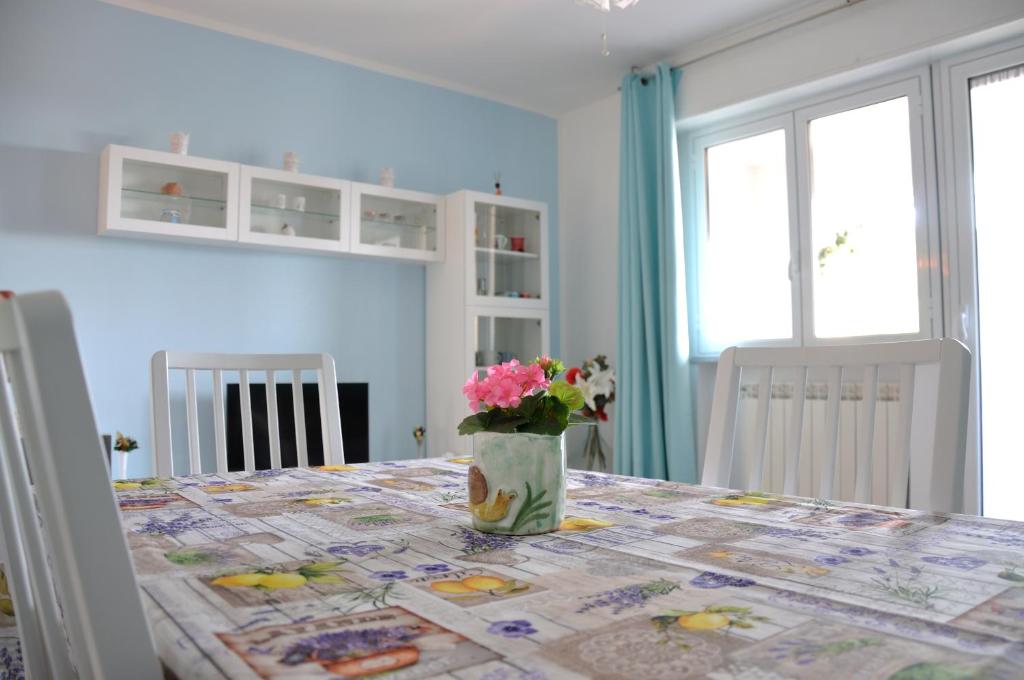 una mesa con un jarrón de flores encima en La casa azzurra en Cogoleto