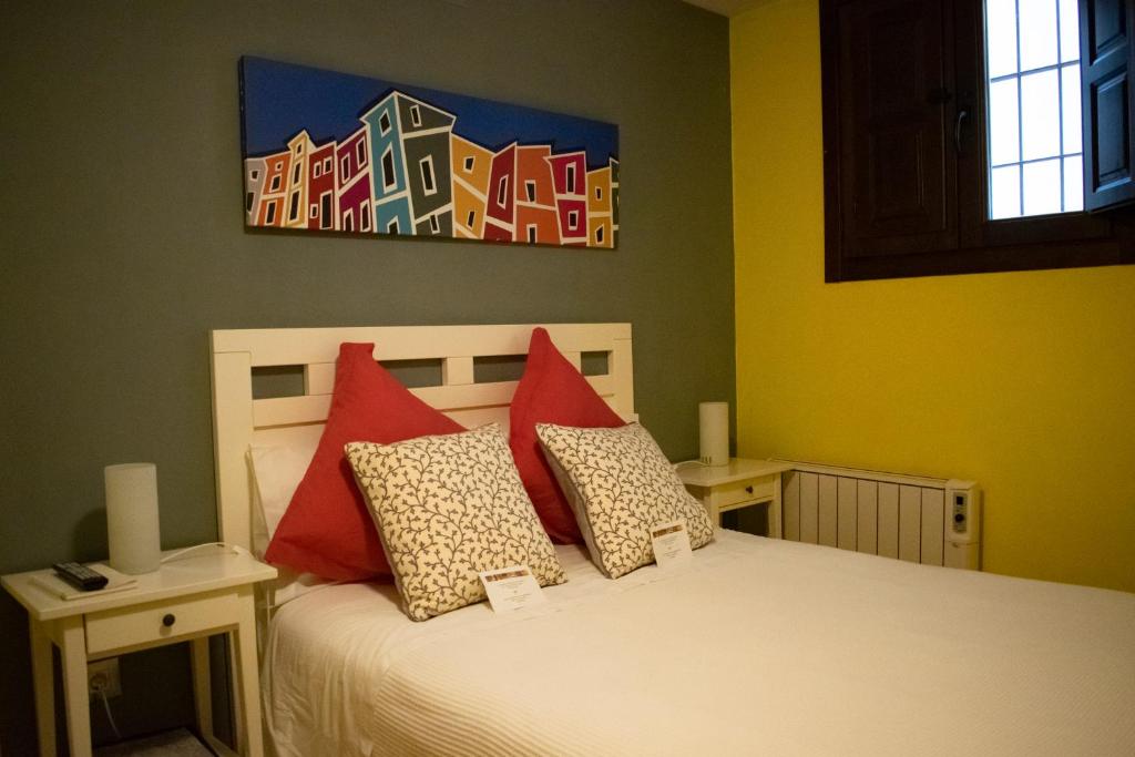 クエンカにあるLa casa de Joseのベッドルーム1室(赤い枕と絵画付)