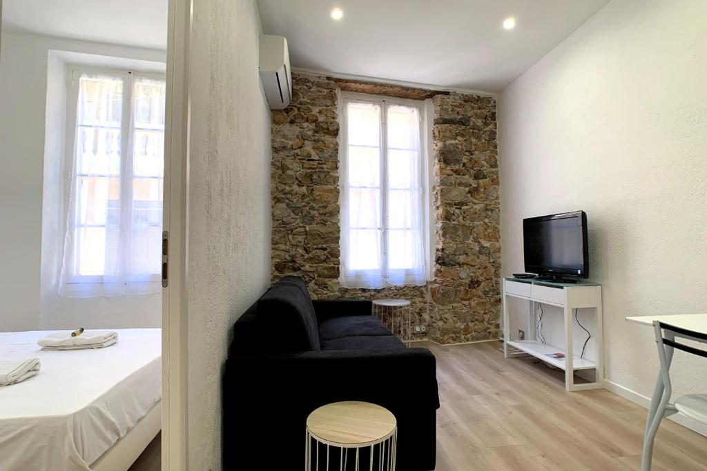 Cette chambre comprend un canapé, un lit et une télévision. dans l'établissement Renovated apartment AC - wifi - 2-4pers - Center Antibes rue James Close, à Antibes
