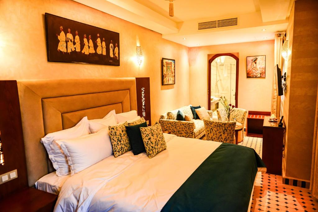 ein Schlafzimmer mit einem Bett und Stühlen in einem Zimmer in der Unterkunft Riad Al mazhar in Rabat