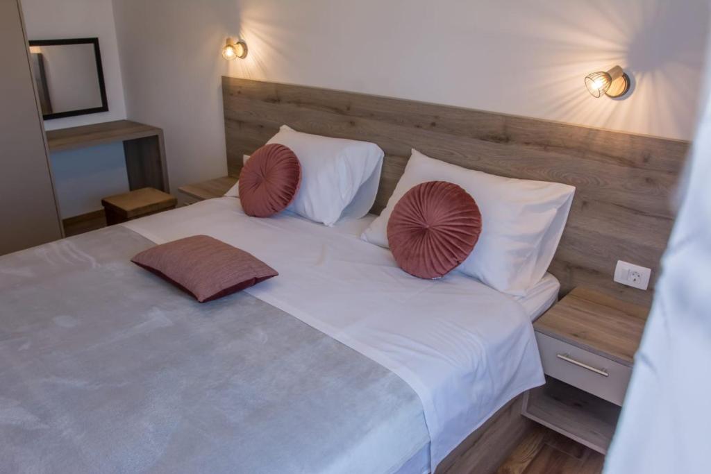 a bedroom with a white bed with two pillows on it at Apartman Joso 2 in Sukošan