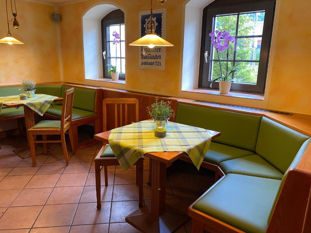 ein Restaurant mit zwei Tischen, einem Sofa und Fenstern in der Unterkunft Kastanienhof in Müglitztal