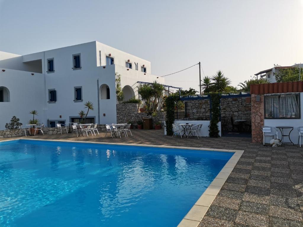 una piscina frente a una casa con un edificio en Mylos, en Livadi