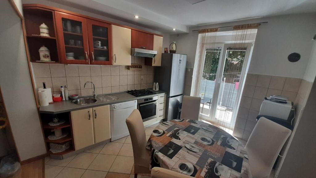 a kitchen with a table and a kitchen with a table and chairs at Apartman Pio in Senj