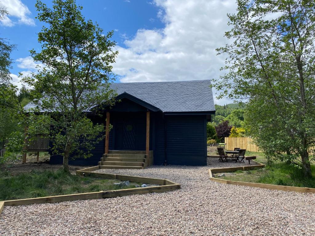 un cobertizo azul con un banco delante de él en Hatton Lodge, en Dunkeld