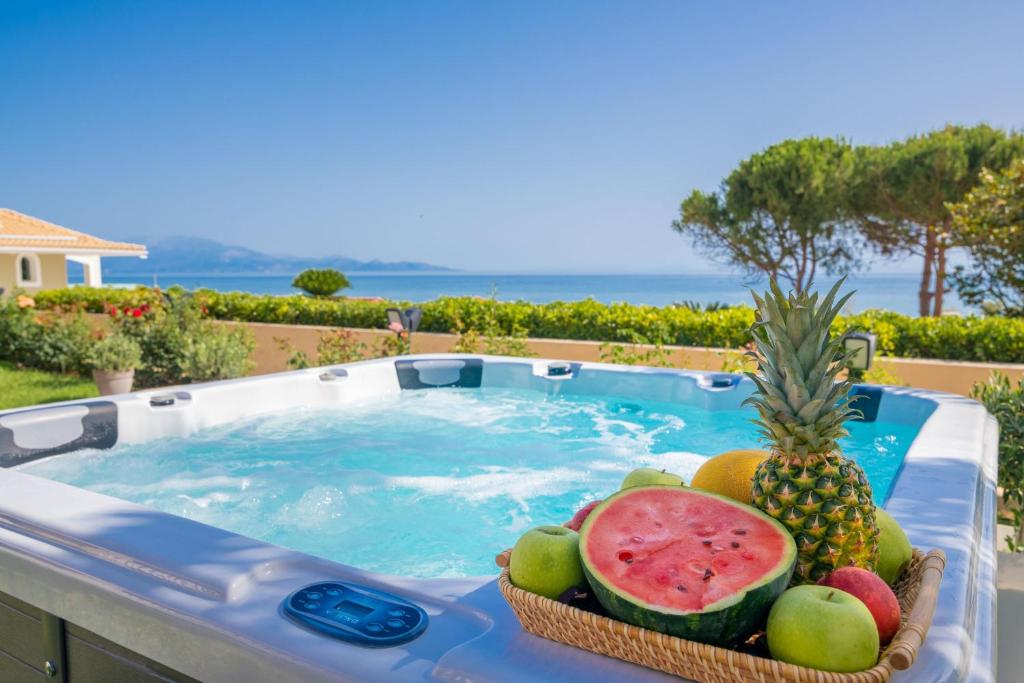 a basket of fruit sitting next to a swimming pool at Sea Elegance Villa in Zakynthos Town