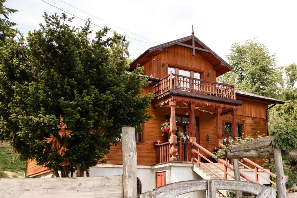 a wooden house with a porch and a balcony at Cisówka Pokoje Gościnne in Piwniczna