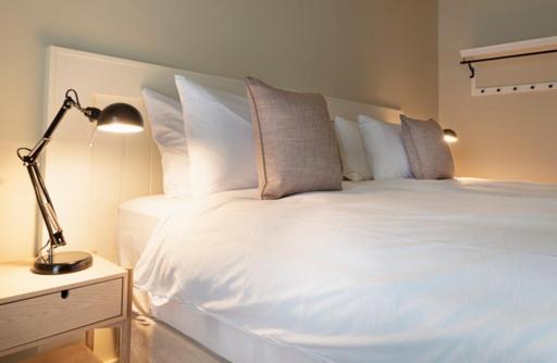 a white bed with pillows and a lamp on a table at Lagom Restaurant & Townhouse in Kenmare