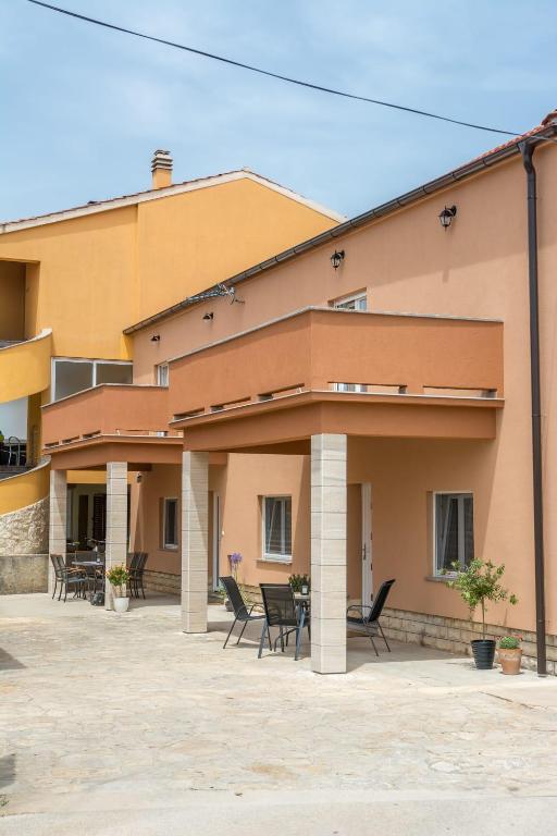 a building with chairs in front of it at Apartman Joso 3 in Sukošan