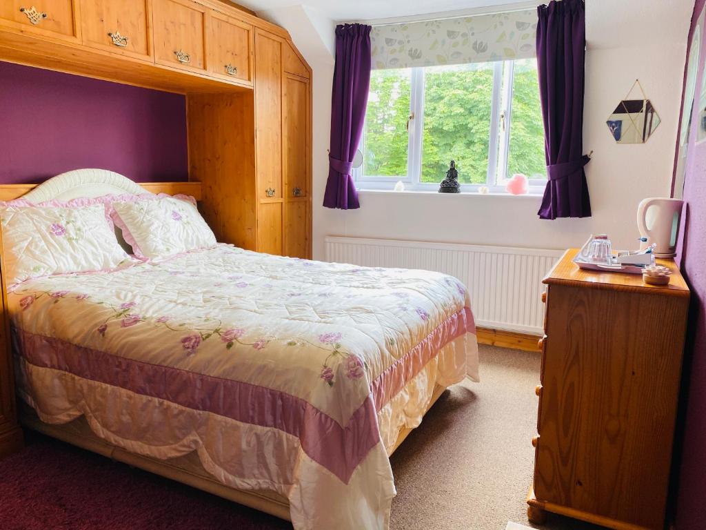 een slaapkamer met een bed en een raam bij Camelot Retreat - Tor View in Glastonbury