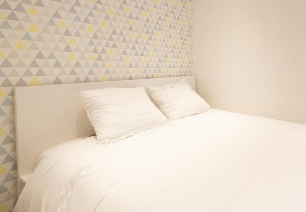 - un lit blanc avec un oreiller dans l'établissement Le cocon du Vieux-Port, à Marseille