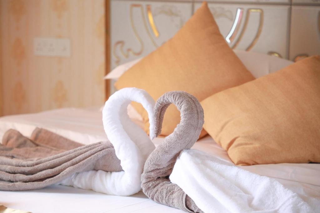 Dos cisnes blancos haciendo un corazón en una cama en Jeym Lodge, en Thoddoo