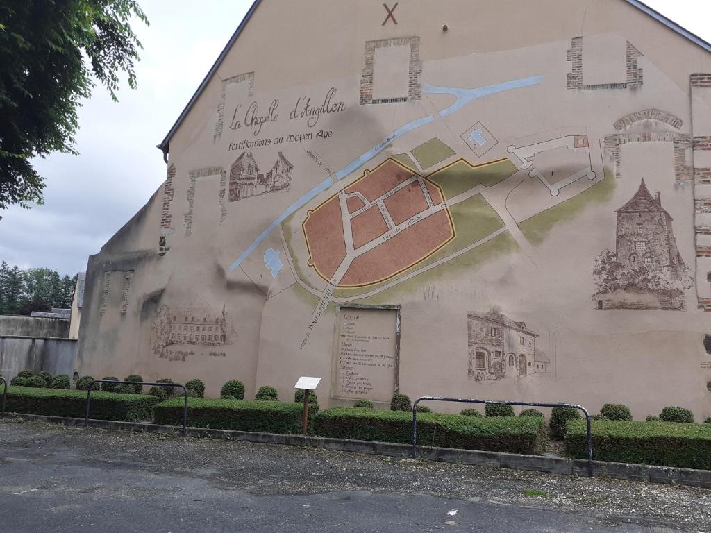 a mural on the side of a building at Ancien Presbytère in La Chapelle-dʼAngillon