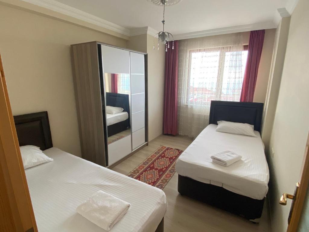 ein kleines Zimmer mit 2 Betten und einem Spiegel in der Unterkunft Ozgurcan Apart & Hotel in Trabzon